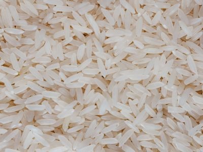 Detailed view of uncooked white rice grains, showcasing texture and pattern.